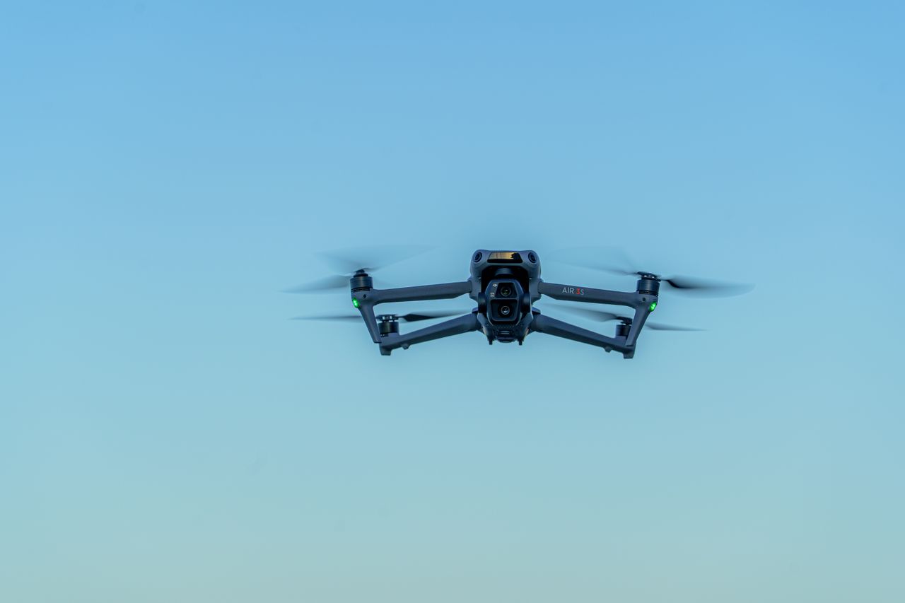 why-choose-us A drone soars through a bright blue sky, showcasing modern aerial technology.